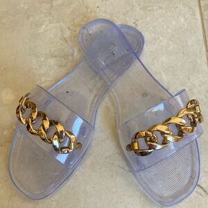 Clear, single strap, sandal with gold chain and embellishment